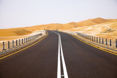 Kum tepeleri Liwa Oasis, Birleşik Arap Emirlikleri üzerinden dolambaçlı siyah asfalt yol