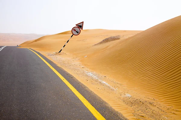 リワのオアシス、アラブ首長国連邦の砂丘を介して巻きの黒いアスファルトの道路 — ストック写真