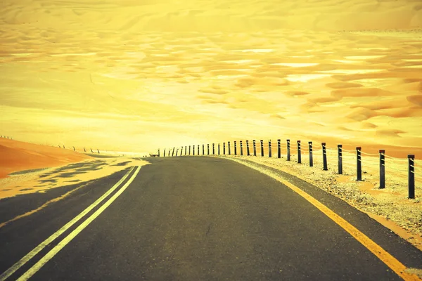 Winding black asphalt road through the sand dunes of Liwa oasis, United Arab Emirates — Stock Photo, Image