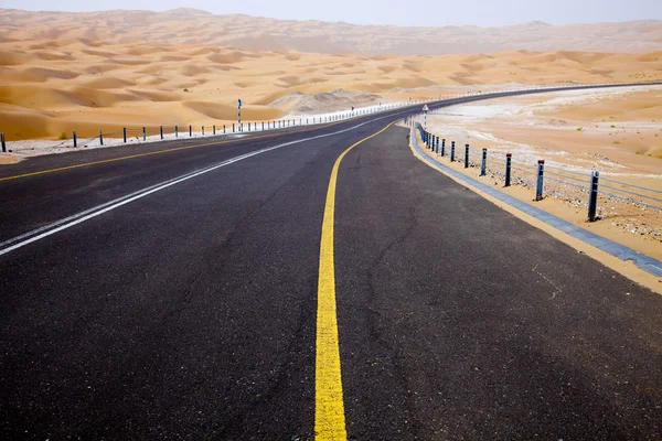 리와 오아시스, 아랍 에미리트 연합국의 모래 언덕을 통해 검은 아스팔트도로 와인딩 — 스톡 사진