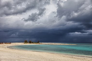 Sunny beach, kara bulutlar ve turkuaz su. Cennet Adası, Bahama Adaları