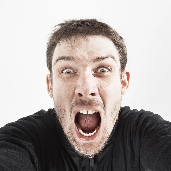 Beyaz bir arka plan üzerinde siyah ceketli tıraşsız adamı bağırır