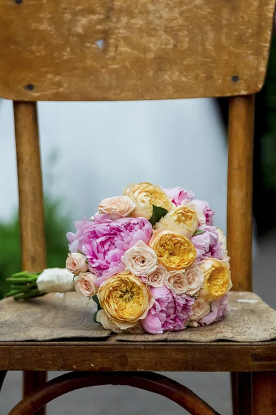 Beautiful wedding bouquet on a wooden shabby chair