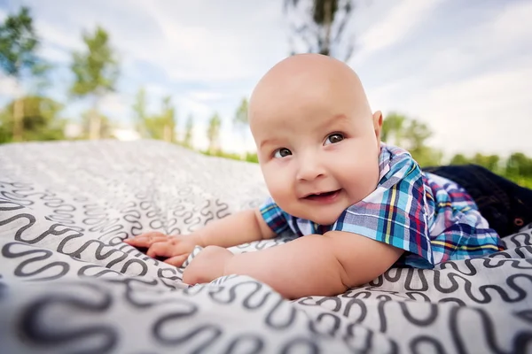 küçük çocuk battaniye üzerinde yalan ekose gömlekli