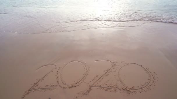 海の波は2020年を一掃白い砂の上に文章を書く午前中に熱帯のビーチビーチで美しい光の日の出と波が砂の海岸でクラッシュ — ストック動画