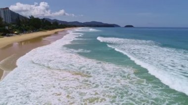 Tropikal kumlu sahilde uçan hava aracı görüntüsü ve Karon sahilindeki beyaz kumlu sahile vuran dalgalar Phuket Tayland