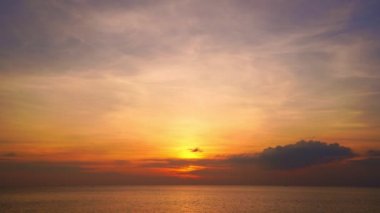 Güneş ufka dokunur, kızıl gökyüzü altın saatinde inanılmaz deniz manzarası, okyanus plajı günbatımları, dönen bulutların içindeki güneş muhteşem doğal gün batımları.