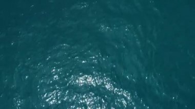 Hava görüntüsü İHA görüntüsü dalgalanır ve açık denizde dalgalanır, üst görünüm deniz kenarı, kamera suyun üzerinde uçar, su yüzeyinin bir görüntüsü, su yüzeyi drone kamera hareketinin arka planı