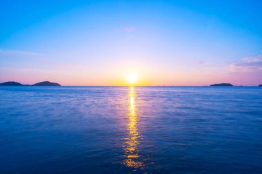 Güzel gün batımı ya da okyanus üzerinde gün doğumu uzun pozlu görüntüde inanılmaz doğa manzarası..