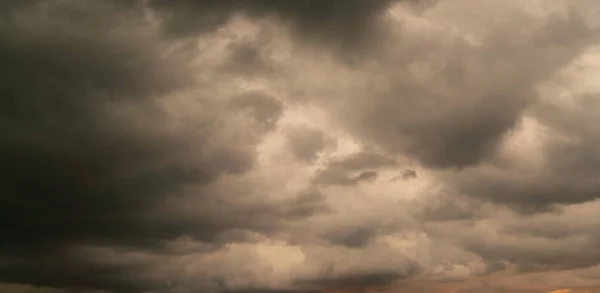 Dark storm cloud Rain clouds in sunset or sunrise sky Dramatic black cloudscape in bad weather day.