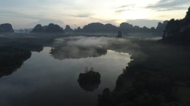 Sabah sisli ve sisli havada güzel okyanusun insansız hava aracı görüntüsü. Gün doğumu dronu denizin ve mangrov ormanlarının üzerinde uçuyor.