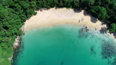 Mavi bir okyanustaki deniz kıyısı kayalarının tepesindeki hava aracı kamerası. Deniz dalgaları güzel deniz manzaralı insansız hava aracı 4k. Yüksek kalitede okyanus dalgaları boş kaya kayalıklarına çarpıyor.
