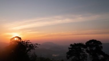 Sinema görüntüsü B-roll zaman ayarlı sisli alacakaranlık gökyüzünde bulutlu hareketler bulutların üzerinde yüksek dağ yağmur ormanlarında sis akıyor. Bulutlu, karışık, güneşli bir gün karışımı engin tepe hızlandırıyor.