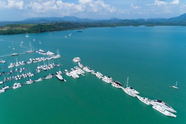 Yat ve yelkenli parkının havadan görüntüsü marina taşımacılığı ve seyahat arka planı Güzel deniz Dağ Mavi gökyüzü bulutları.
