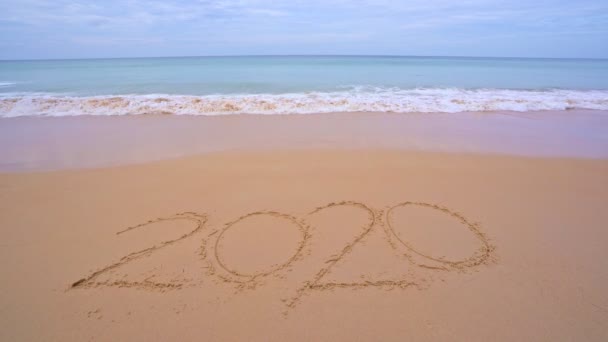 海の波は2020年を一掃白い砂の上にテキストの書き込み午前中に熱帯のビーチ美しい白い砂浜と波が砂の海岸でクラッシュ幸せな新年のコンセプト — ストック動画