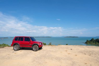 3 Mart 2021 Kırmızı 4x4 Kırmızı araba Suzuki Vitara 1993 Yüksek dağ manzaralı Phuket Tayland 'da gün doğumunda güzel deniz manzaralı.