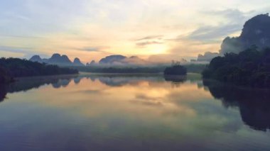 Sabah sisli sisli havada güzel okyanusun insansız hava aracı görüntüsü. Gün doğumu dronu denizin ve mangrov ormanlarının üzerinde uçuyor. Yüksek açı, Dinamik hava görüntüsü.