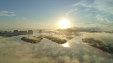 Yoğun sis bulutları dağların üzerinden ya da gün batımında hareket eder. Sis manzaralı hava manzaralı. Hava aracı yağmur ormanları üzerinde uçar. Güneş doğarken bulutlar ve sis. Doğa konsepti.