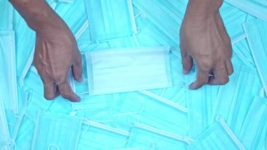 Grip virüsünden korunmak için insan eli maskesi ya da yüz maskesi. Yüzeydeki tıbbi malzeme maskeleri, Coronavirüs bulaşmasını önlemek için takılıyor.