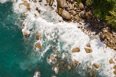 Muhteşem hava manzarası yaz mevsiminde kayalara çarpan tropikal deniz dalgalarıyla dolu güzel dağ kıyılarının insansız hava aracı görüntüsü seyahat ve seyahat arka planı ve seyahat web sitesi.