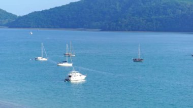 Tayland 'ın Phuket Adası' nda yaz denizi. Yelkenli tekneleri, yatları ve deniz manzaralı seyahat tekneleri olan güzel tropikal deniz. Tayland seyahati ve iş gezisi arka planı.