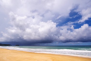 Okyanus 'un kıyı şeridi boyunca uzanan mesafesine sağanak yağış ile denizin üzerinde dramatik bir kara fırtına var. Pofet adasındaki sakin plajdan manzara. Çevre, iklim değişikliği kavramları.