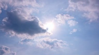 Parlak güneş ışınları, güneşli bulutların arasından parlayan parlak güneş ışınları. Güneşli bulutlar arasından parlayan bulutlar, tropikal yaz günü güneşli bir günde güneşli bir arka planda. Güneş enerjisi.