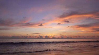 Dramatik deniz batımı ya da gün doğumu Yanan altın gökyüzü ve parlayan altın dalgalar Deniz yüzeyinde güzel bir ışık yansıması Phuket Adası 'ndaki 4K görüntüsü, Tayland seyahat arka planı