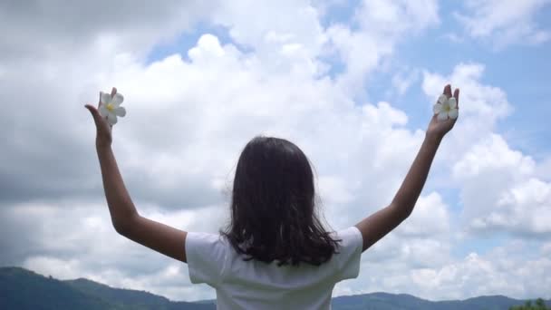 Szczęśliwa Młoda Dziewczyna Białą Plumerią Ręku Podniesionymi Rękami Błękitnym Niebie — Wideo stockowe