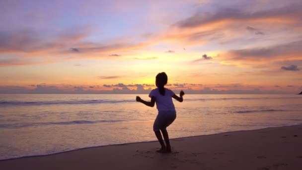 Silueta Joven Saltando Playa Levantando Las Manos Playa Atardecer Increíble — Vídeos de Stock