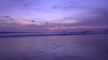 Dramatik deniz batımı ya da gün doğumu Yanan mor gökyüzü ve parlayan beyaz dalgalar kumlu sahile çarpıyor Deniz yüzeyindeki güzel ışık yansıması İnanılmaz manzara ya da deniz manzarası