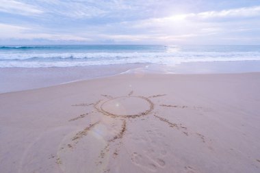 Deniz kenarında kumsalda güneşin işareti. Yaz tatili konsepti, kumlu kıyıya vuran köpük dalgası. Yazın yazlık ve seyahat tatil arka planında yer alan harika deniz kıyısı afişi.