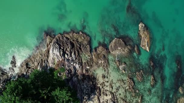 天気の良い夏の日に岩の上に詳細波がクラッシュしてプーケット島の美しい海の岩の海岸線の空中ビュー素晴らしい海の表面観光や休暇のコンセプト — ストック動画