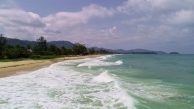 Hava manzaralı kumlu sahil ve dalgalar güzel tropikal deniz yaz mevsiminde Havadan görünüşlü insansız hava aracı yüksek açılı görüntüyü aşağı çeker.