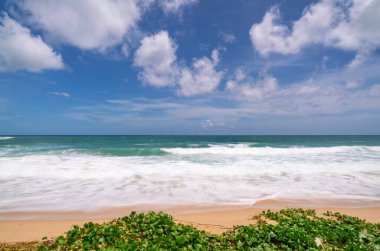 Boş tropikal yaz plaj arka planı gökyüzü ve kumlu sahile vuran beyaz kumsal dalgası ile Horizon