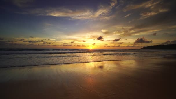 戏剧化的海洋日落或日出燃烧着紫色的天空和闪耀的白浪冲撞在沙滩上海面上美丽的光反射迷人的风景或海景背景 — 图库视频影像