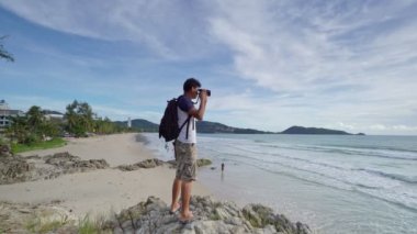 4K Profesyonel adam Patong plajı Phuket Thailand 'da manzara manzarası için aynasız kamera ayarlıyor, Phuket' in ünlü turizm merkezi.