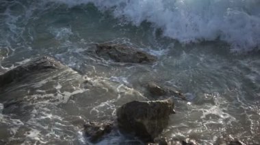 Yaklaş dalgalar kıyıları ezer Güzel dalgalar deniz köpüğü Dalgaların gücü tehlikeli kayalıkların üzerinden ağır çekimde geçer