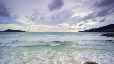 Güneşli bir yaz gününde kumlu kıyıya vuran dalgalı güzel deniz kıyısı. Phuket Adası Tayland 'da güzel bir gün.