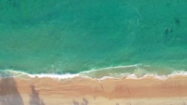 Hava manzaralı kumlu sahil ve dalgalar güzel tropikal deniz yaz mevsiminde Havadan görünüşlü insansız hava aracı yüksek açılı görüntüyü aşağı çeker.