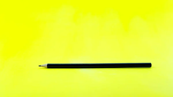 Black Pencil Yellow Paper Background — Stock Photo, Image