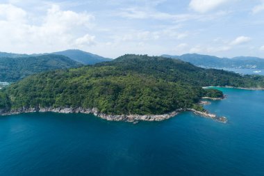 Yüksek açılı tropikal deniz dalgaları deniz kıyısına çarpıyor ve yüksek dağ Phuket Tayland 'da yer alıyor. Havadan kumandalı hava aracı aşağı iniyor. İnanılmaz doğa manzarası. Güzel deniz yüzeyi.