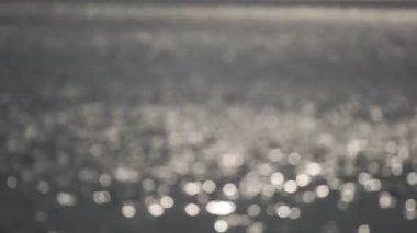 Bokeh güneşi, gün batımının su yüzeyindeki gündoğumu ışığının parlak yansıması. Okyanusta titreşen güneş ışınları güneşte parıldayan deniz dalgaları odak dışı bulanıklık Bokeh Şaşırtıcı sonbahar arka planı