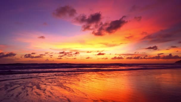 カラフルな空の夕日や日の出カラフルな空と輝く波が砂の海岸にクラッシュ海の表面に美しい光の反射驚くべき風景や海の自然夕暮れの背景 — ストック動画