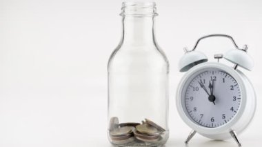 Hareket animasyon sikkelerini beyaz arkaplan üzerinde izole edilmiş beyaz alarm saati olan cam kavanoza yerleştir. Finans ve iş bankacılığı arkaplanı Görüntü Zamanı Hızı Kopyalama alanı