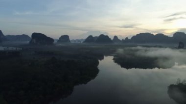 Sabahın sisli sabahında gökyüzüne karşı inanılmaz sisli ve güzel okyanusun insansız hava aracı görüntüsü deniz ve mangrov ormanları üzerinde uçuyor.