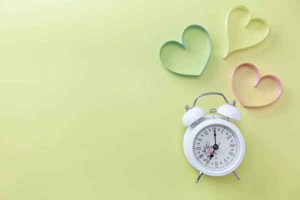 World heart day banner background White alarm clock and Heart symbol on table background Medical concept.