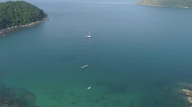 Mavi bir okyanus turkuaz deniz yüzeyinde, deniz kıyılarındaki kayaların tepesindeki hava görüntüsü kamerası. Deniz dalgaları güzel deniz manzaralı dron 4k Taş kayalıklı yüksek kalite okyanus