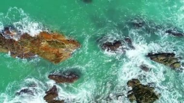 Dalgaların hava görüntüsü kayalara çarpıyor mavi okyanus dalgaları güzel deniz manzaralı insansız hava aracı 4k 'ye çarpıyor inanılmaz deniz manzarası insansız hava aracı kamerasından yüksek kaliteli görüntüler.