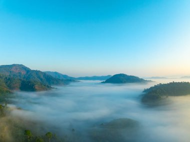 Tropikal yağmur ormanlarında akan sis dalgalarının hava görüntüsü bulutların üzerindeki kuş bakışı görüntü Tayland 'da bulutlar ve dağ zirveleriyle dolu arka plan.